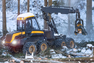 Harvester in action in a snow-covered forest