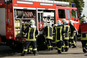 Group of firefighters unloading equipment from the emergency vehicle.