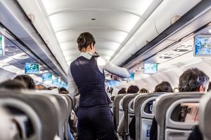 Flight attendant serving water on a passenger plane