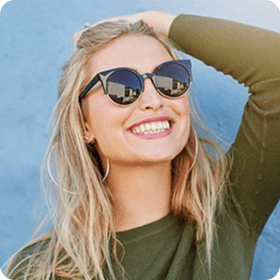woman posing while wearing sunglasses
