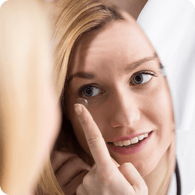a woman fitting her contact lens